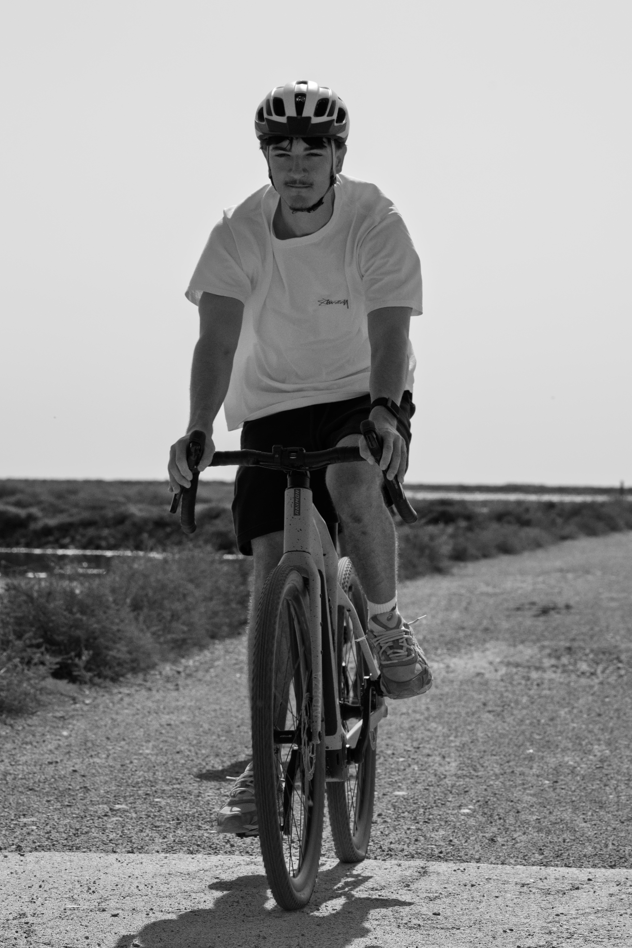 Vertical portrait of a cyclist on the gravel path, Gruissan