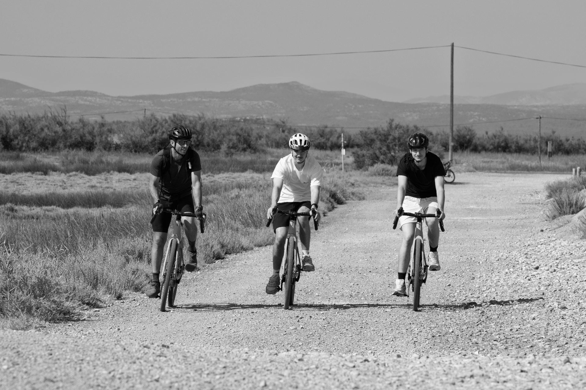 Group of cyclists on the gravel trails, lagoon landscape, Gruissan