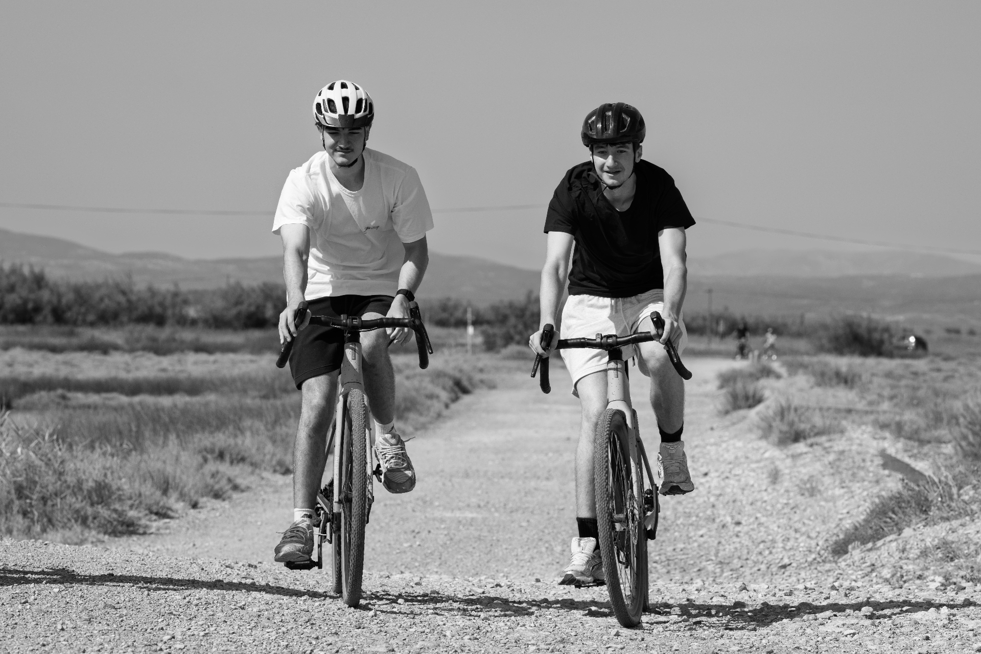 Two cyclists side by side on a gravel track, Gruissan