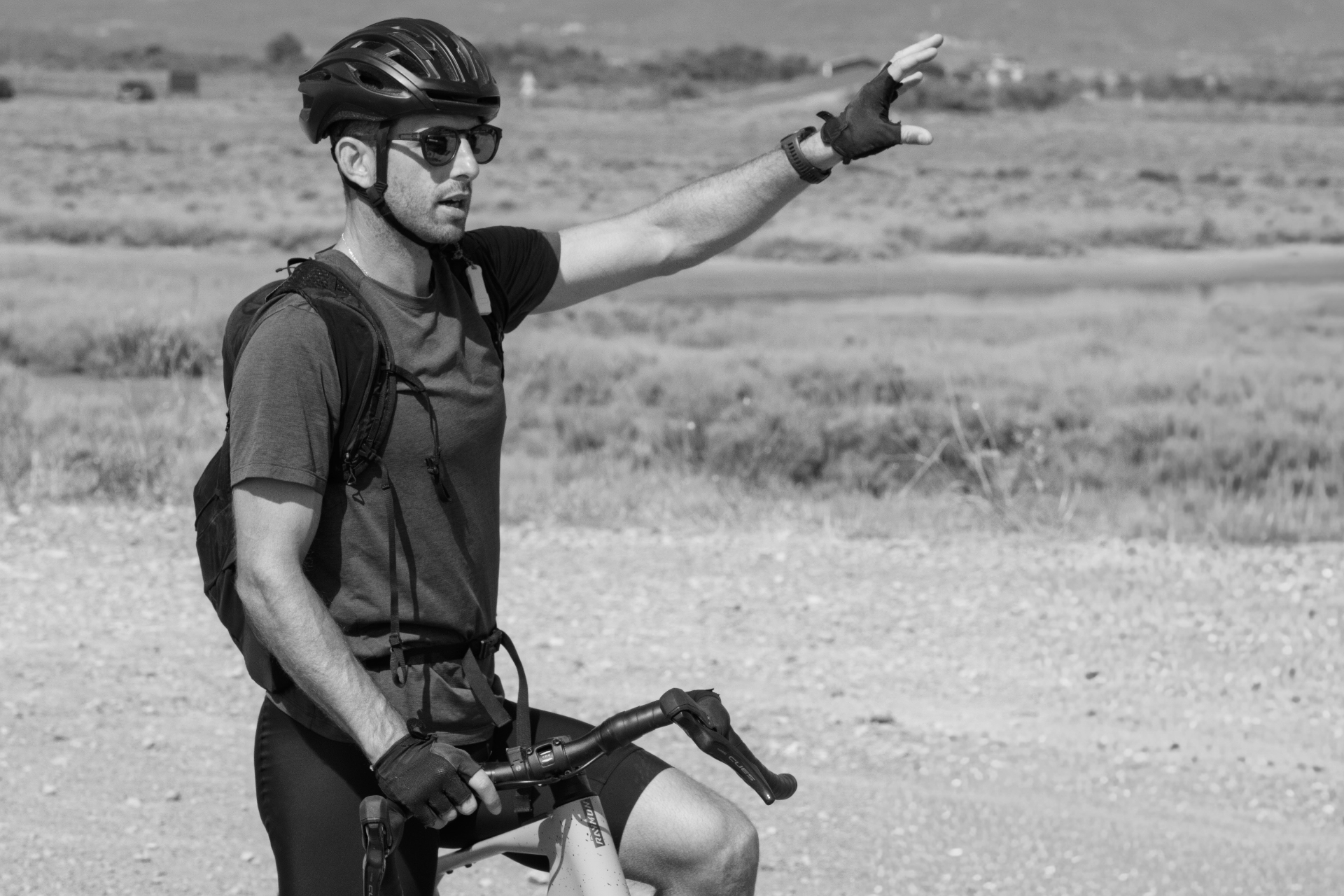 Cyclist gesturing on a gravel trail, Gruissan